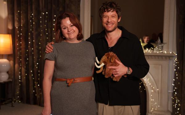 author Dr Rose Stewart smiles and poses for photo with actor James Norton, who is holding a stuffed mammoth toy