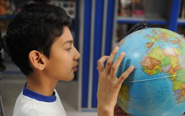 A boy pointing at a globe model