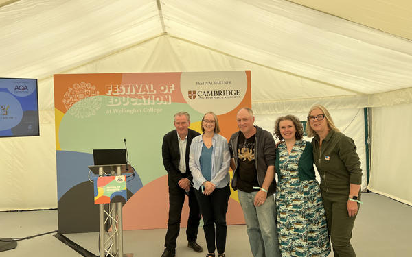 5 colleagues stand posing for a photo before going on stage at Festival of Education