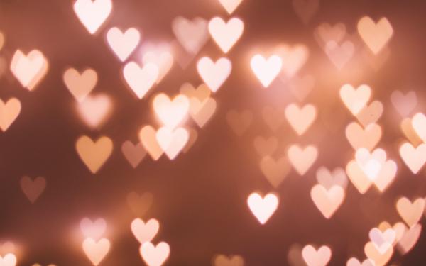 a dark pink background with numerous small pink heart lights